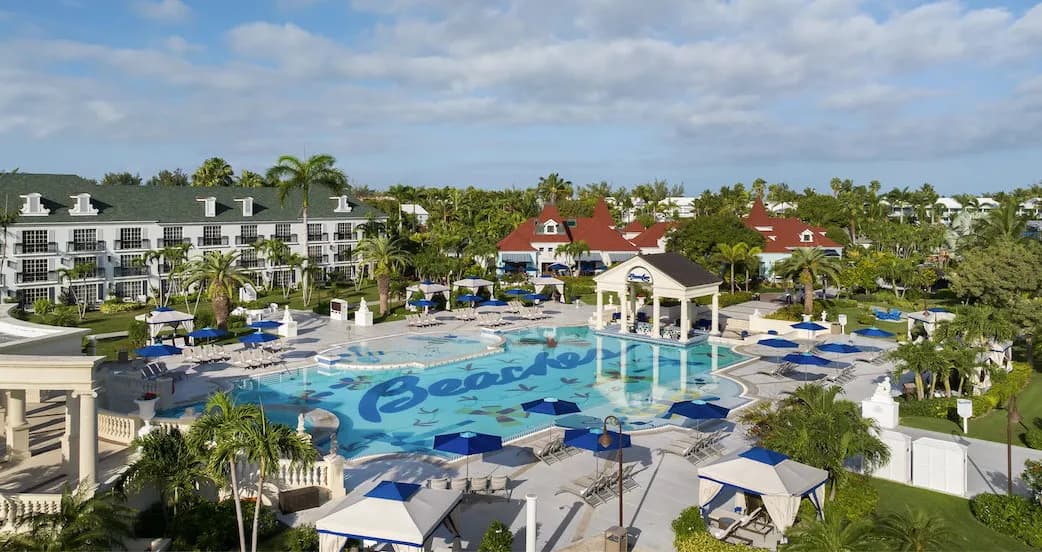 A large pool with the Beaches logo and lounge chairs surrounding it A large pool with the Beaches logo and lounge chairs surrounding it